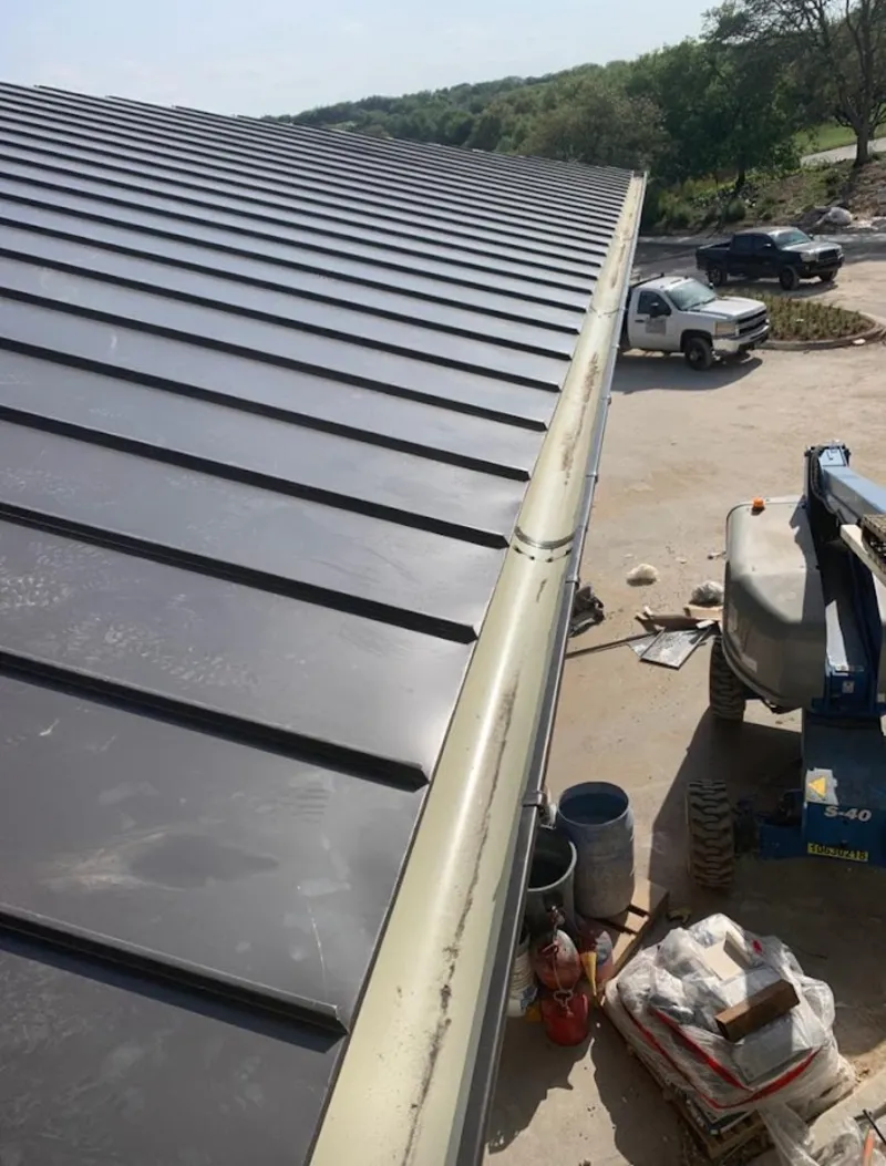 Standing seam panel and gutter detail on a metal roofing jobsite in Wallington